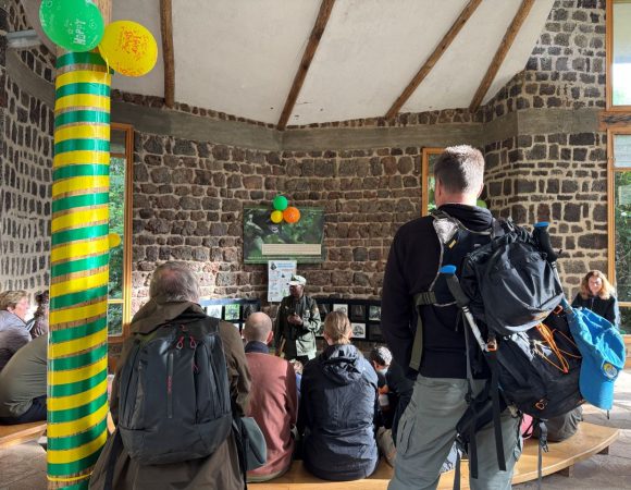 Tourists in a room listening to a briefing from a ranger guide