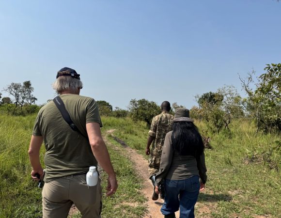 A couple with a ranger guide walking on a sunny day