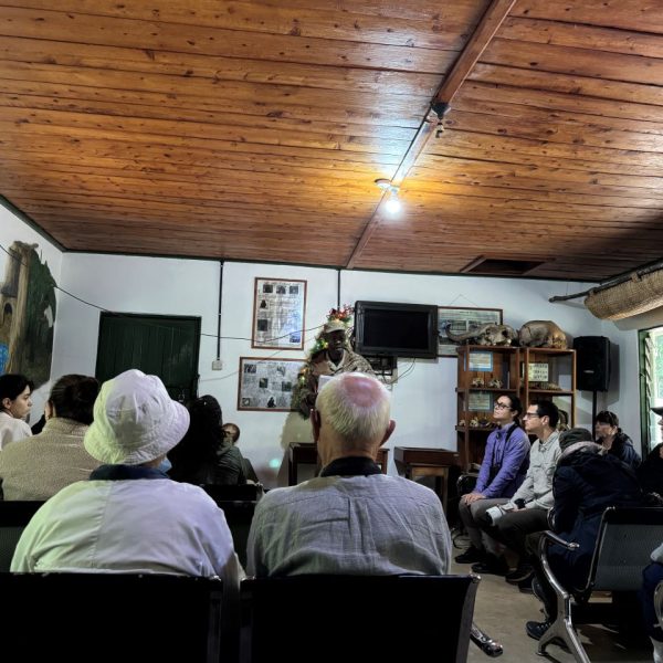 People seated on chairs in a room