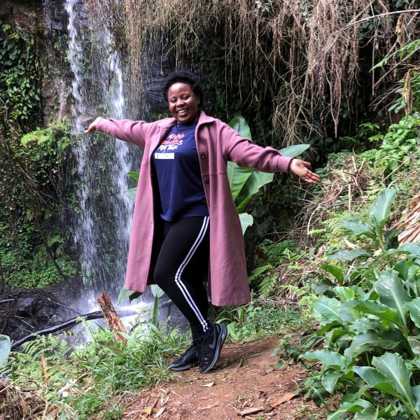 A woman standing in front of a stream of water 