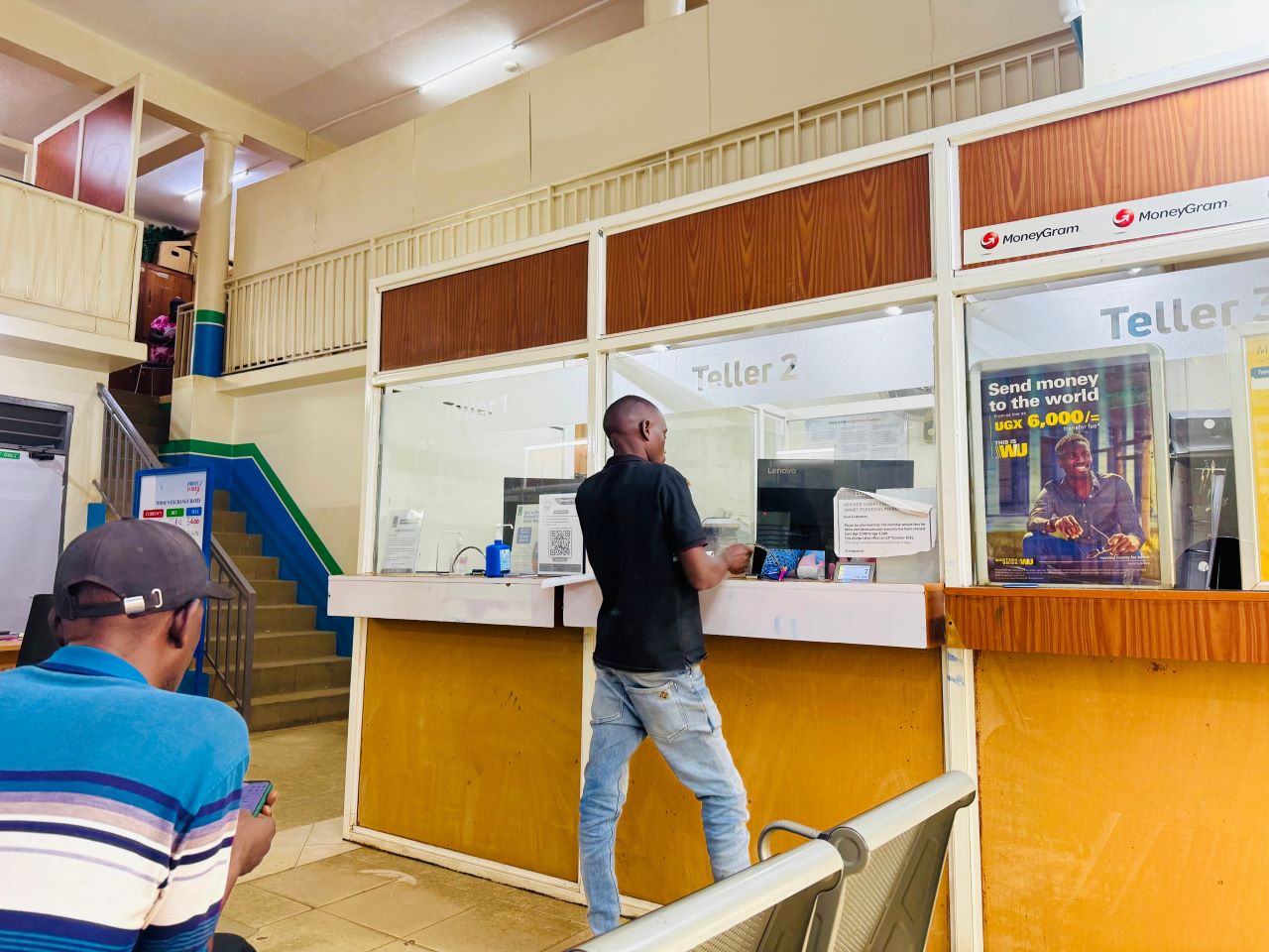 A man standing in front of a teller at the bank