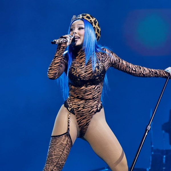 A singer with blue hair holding a microphone