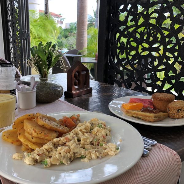 Eggs, potatoes and pastries on white plates
