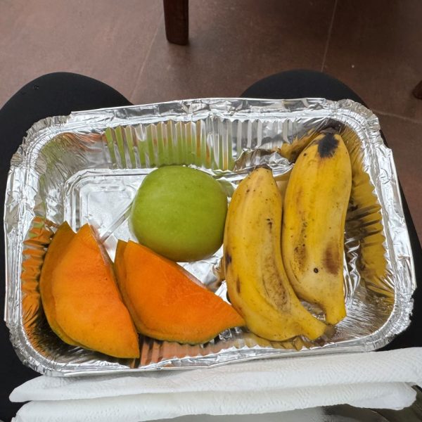 Bananas, a mango and an apple in a silver plate