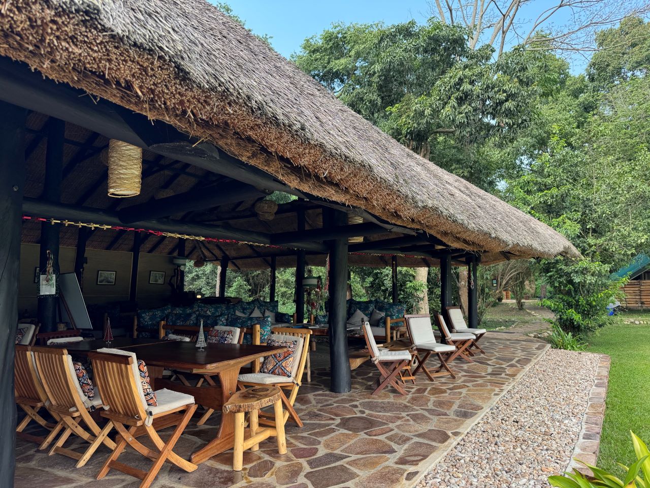 Grass thatched safari camp lounge surrounded by trees