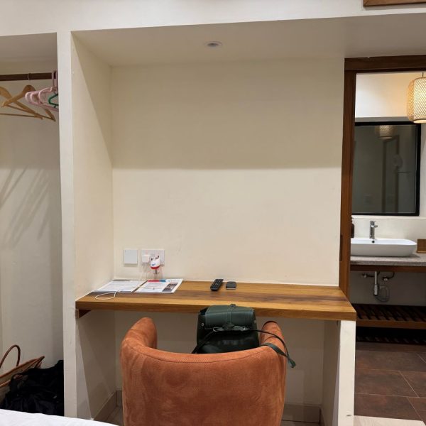 Hotel room with an orange chair and an entrance leading to another bathroom 