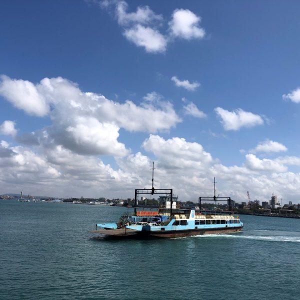 A blue ferry sailing on ocean waters
