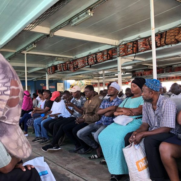 A number of people seated on seats in public transport