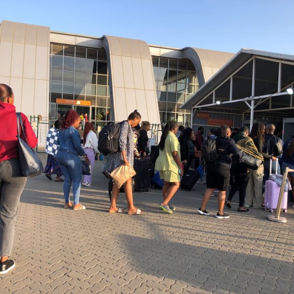 People standing in line on a paved surface