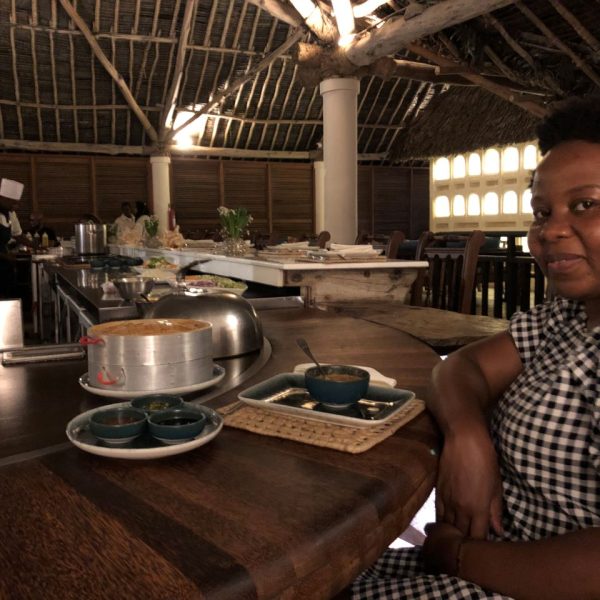 A woman seated at a dinner table with food in front of her 