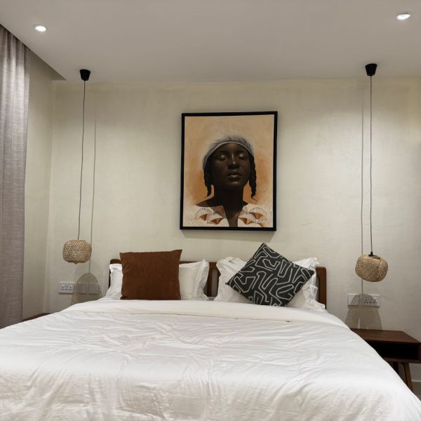 Bed with an art piece on the wall