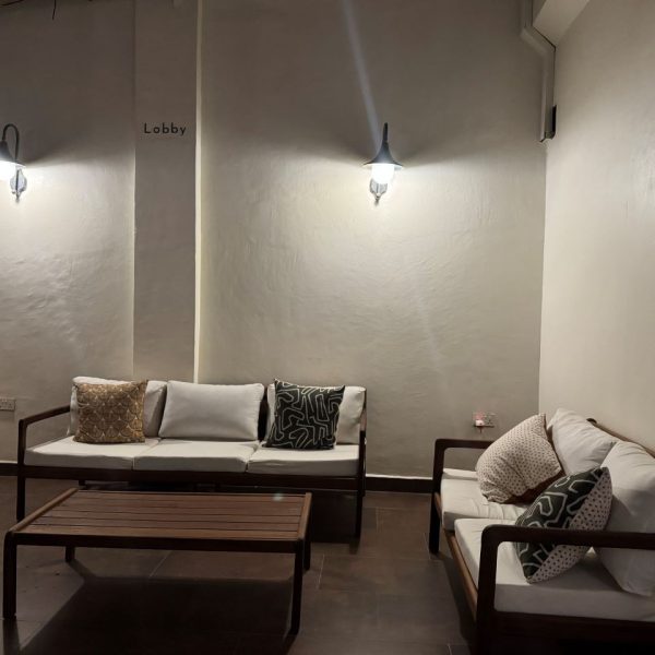 Brown wooden sofas with white cushions 