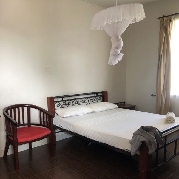 A bed with white bed sheets 