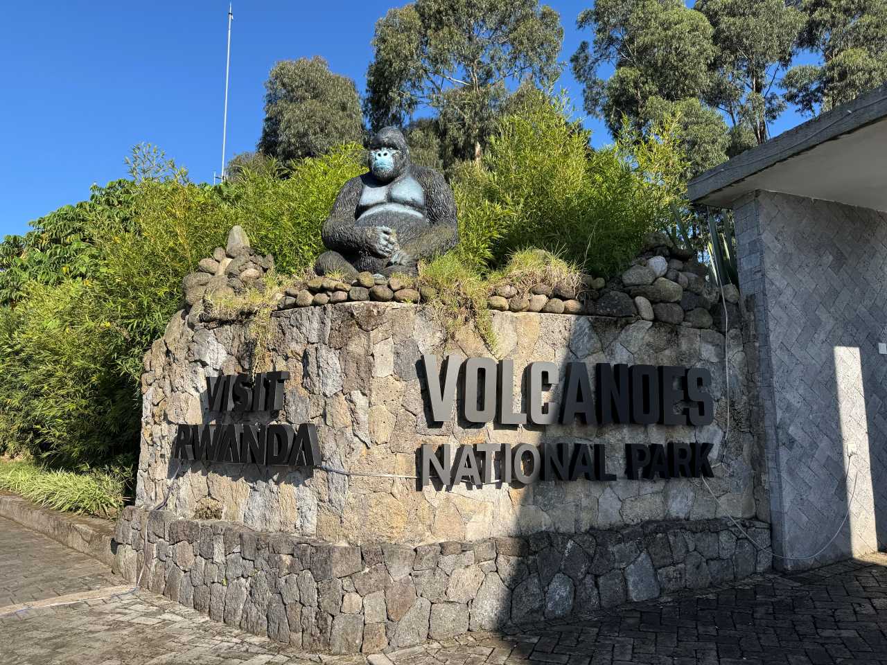 A national park sign post with a gorilla sculpture
